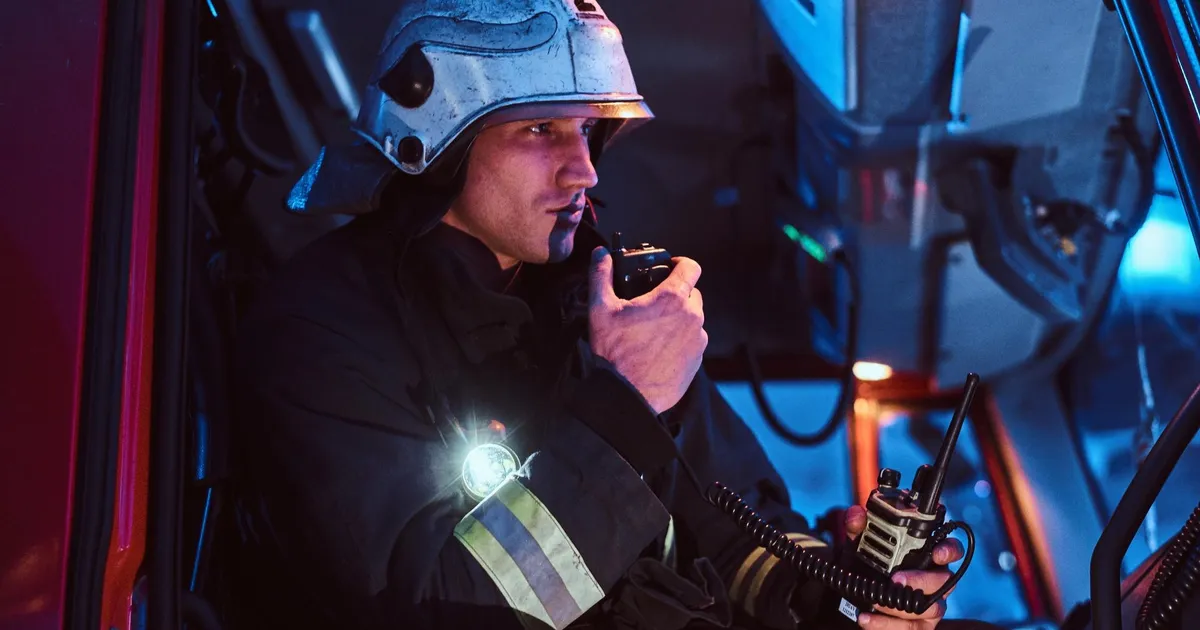 Pompier utilisant une radio de communication de crise la nuit lors d'une intervention d'urgence