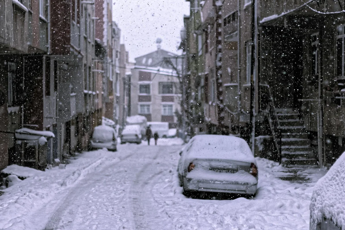 Rue enneigée avec voitures pendant une chute de neige extrême